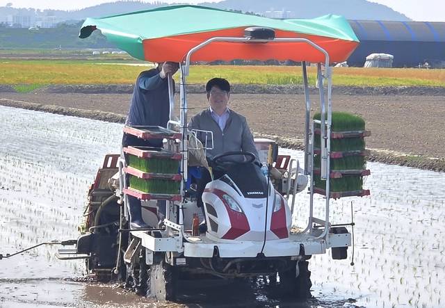 권재한 농촌진흥청장(오른쪽)이 5월29일 전북 부안군 부안읍의 ‘마른논 써레질’을 적용한 후 물을 댄 논에서 이앙기를 타고 모내기를 하고 있다.