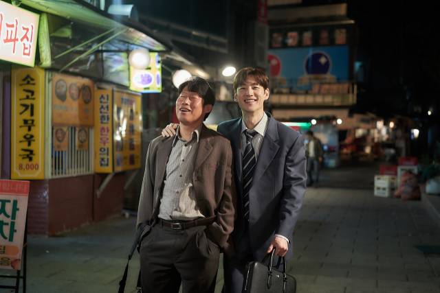 영화 '소주전쟁'의 한 장면으로 국보소주의 재무이사역 표종록 역의 유해진(왼쪽)과 글로벌 투자자문사 솔퀸의 인범 역 이제훈. 사진 제공=쇼박스
