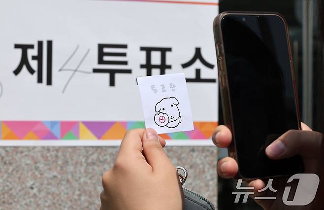 제21대 대통령 선거일인 3일 서울 서대문구 서울창서초등학교에 마련된 신천동 제5투표소를 찾은 유권자가 투표를 마친 후 인증샷을 찍고 있다. 2025.6.3/뉴스1 ⓒ News1 김성진 기자