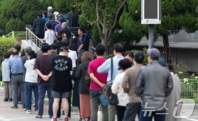 제21대 대통령 선거일인 3일 서울 영등포구 여의도 윤중중학교에 마련된 투표소를 찾은 시민들이 길게 줄 서 있다. 2025.6.3/뉴스1 ⓒ News1 이승배 기자