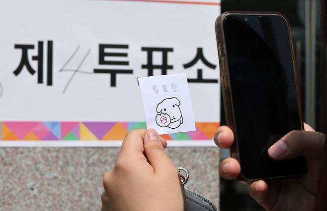 제21대 대통령 선거일인 3일 유권자가 투표를 마친 후 ‘가나디’ 캐릭터가 그려진 투표 인증 용지로 인증샷을 찍고 있다. 뉴스1