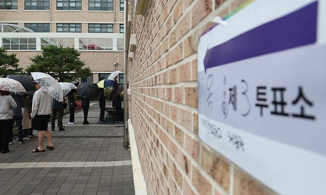제21대 대통령 선거일인 3일 울산시 남구 신정중학교 체육관에 마련된 옥동 제3투표소에서 유권자들이 우산을 쓰고 투표를 기다리고 있다. 연합뉴스