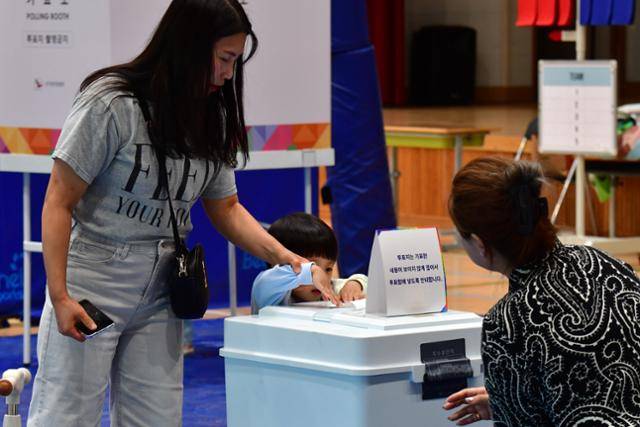 제21대 대통령 선거일인 3일 경북 포항시 남구 오천읍 문덕초등학교에 마련된 투표소에서 어린이가 엄마의 투표용지를 기표함에 넣고 있다. 포항=뉴스1