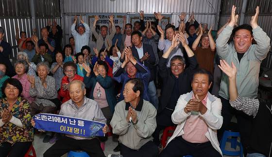 3일 더불어민주당 이재명 대선 후보의 고향인 경북 안동시 예안면 도촌리의 경로당 창고에서 마을 주민들이 제21대 대통령 선거 출구조사 결과를 확인하고 환호하고 있다. 연합뉴스