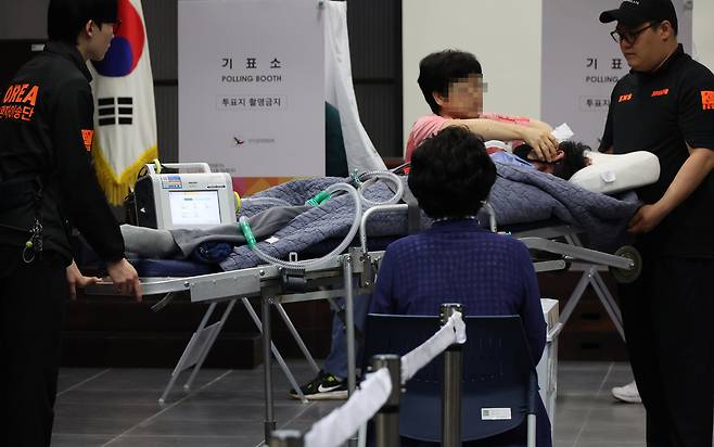 3일 서울 용산구 중부기술교육원에 마련된 한남동 제3투표소에서 한 환자가 보호자와 구급대원의 도움을 받아 투표에 참여하고 있다. 연합뉴스