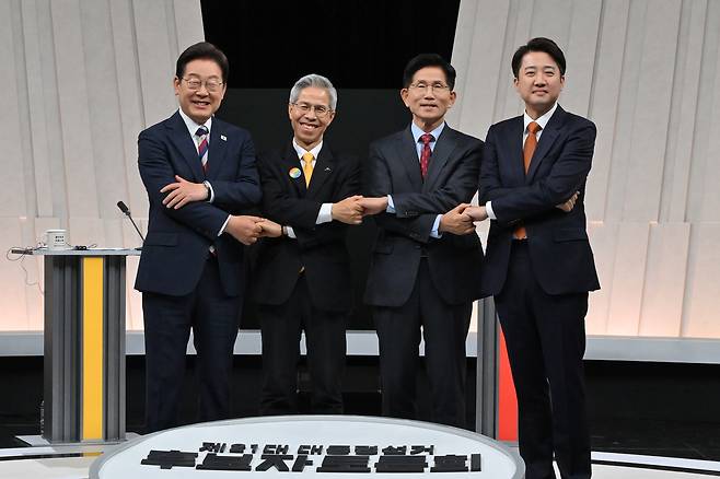 From left, Lee Jae-myung of the Democratic Party, Kwon Young-kook of the Democratic Labor Party, Kim Moon-soo of the People Power Party and Lee Jun-seok of the minor Reform Party pose for a photo ahead of their third and final debate at the MBC studio in Mapo District, western Seoul, on May 27. [JOINT PRESS CORPS]