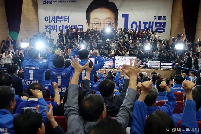[서울=뉴시스] 조성우 기자 =이재명 더불어민주당 대선후보의 선거상황실이 차려진 국회의원회관 대회의실에서 출구조사 결과가 이 후보의 우위로 나타나자 당직자들이 환호하고 있다. (공동취재)  2025.06.03. photo@newsis.com /사진=조성봉