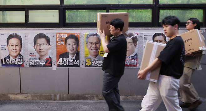 제21대 대통령선거 사전투표 둘째 날인 지난달 30일 서울 중구 소공동주민센터에 마련된 사전투표소에서 사전투표사무원들이 관내 사전투표함과 관외 사전투표지를 이송하고 있다. [연합]