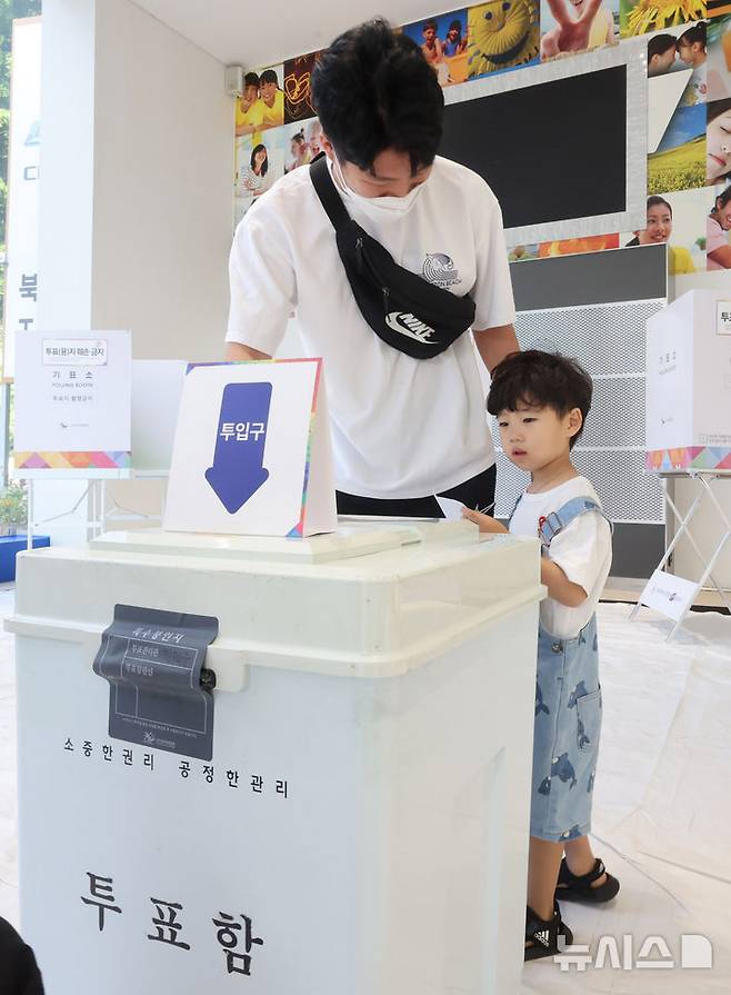 [인천=뉴시스] 전진환 기자 = 제21대 대통령선거일인 3일 오전 인천 미추홀구 한 자동차영업소에 마련된 주안5동 제3투표소에서 한 어린이가 아빵의 투표를 지켜보고 있다 2025.06.03.  amin2@newsis.com