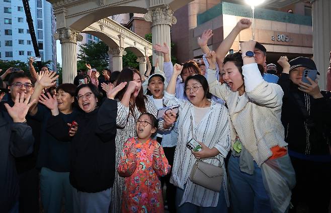 제21대 대통령 선거일인 3일 오후 더불어민주당 이재명 후보의 자택인 인천 계양구 아파트 주민들이 핸드폰으로 방송사 출구조사 결과를 보며 환호하고 있다. 연합뉴스