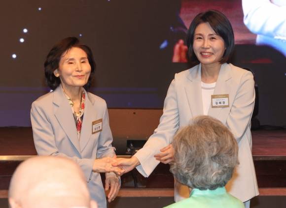 국민의힘 김문수 대선 후보의 부인 설난영씨와 더불어민주당 이재명 대선 후보의 부인 김혜경씨가 12일 서울 중구 신라호텔에서 열린 중앙신도회 창립 70주년 기념식에서 손을 맞잡고 있다. 2025.5.12 연합뉴스