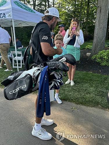 백을 멘 호마가 팬에게 사인해주고 있다.  [AP=연합뉴스]