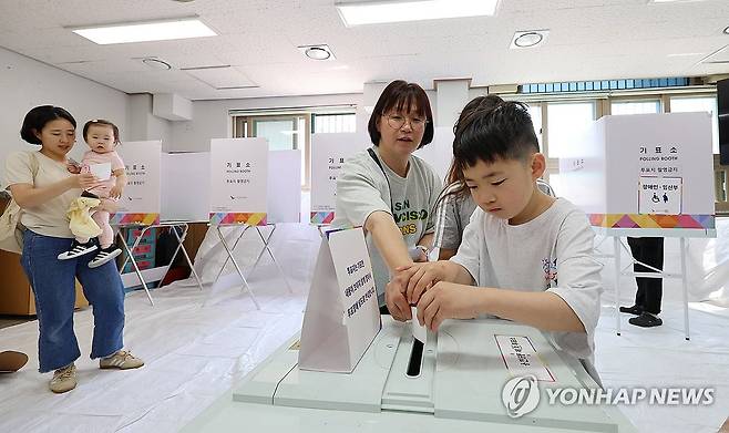 엄마와 함께 투표 (인천=연합뉴스) 임순석 기자 = 제21대 대통령 선거일인 3일 인천 미추홀구 용현중학교에 마련된 용현5동 제5투표소에서 어린이가 엄마와 함께 투표하고 있다. 2025.6.3 soonseok02@yna.co.kr