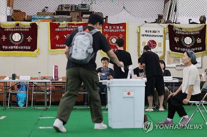 야구장이 투표소로 (서울=연합뉴스) 임화영 기자 = 제21대 대통령선거 투표일인 3일 서울 중구 청구초등학교 야구부실내훈련장에 마련된 청구동제1투표소에서 유권자가 투표하고 있다. 2025.6.3 hwayoung7@yna.co.kr