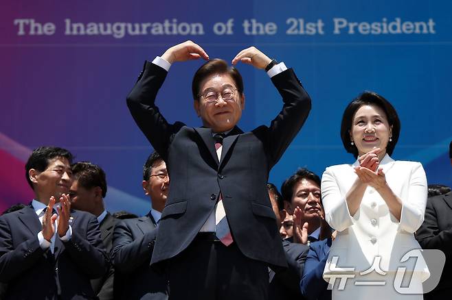 이재명 대통령과 김혜경 여사가 4일 오전 서울 여의도 국회 로텐더홀에서 취임 선서를 마치고 나와 잔디광장에 모인 시민들을 향해 하트를 만들어 보이고 있다. 2025.6.4/뉴스1 ⓒ News1 국회사진기자단