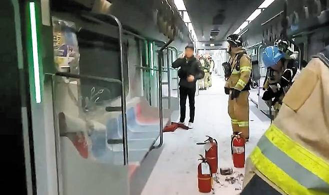 지난달 31일 서울 지하철 5호선 열차 방화 발생 직후 열차 내부에 소방대원들이 진입해 상황을 점검하고 있다. 내부 시설이 거의 불타지 않았다. 바닥에 시민들이 직접 들고 온 것으로 추정되는 소화기 3개가 있다. /영등포소방서