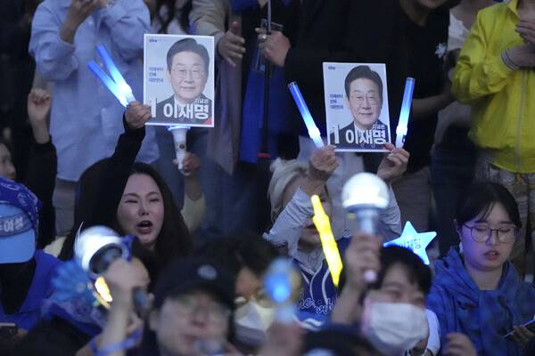 한국 민주당 대통령 후보 이재명 지지자들이 2025년 6월 3일 화요일 서울 국회 앞 광장에서 이재명의 사진을 들고 있다. AP 연합뉴스