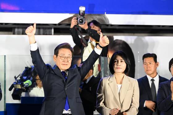 Lee Jae-myung and his wife Kim Hye-kyung celebrate on stage in Yeouido, central Seoul in the early hours of the morning on June 4.  [JOINT PRESS CORPS]