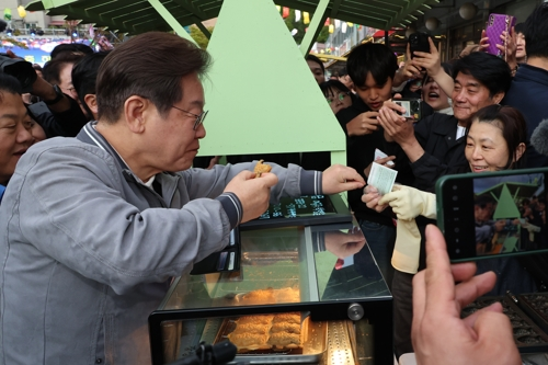 이재명 대통령이 대선 후보 당시 강원도 태백시 장성동 산나물 축제장에서 붕어빵을 사먹으며 유세하는 모습. [사진 출처 = 연합뉴스]