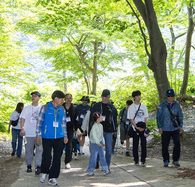 트래킹대회에 참여한 청소년들이 최종술(사진 죄측) 울릉군 문화체육과장으로 부터  나리분지 숲길에 대해 설명듣고 있다[울릉군 제공]
