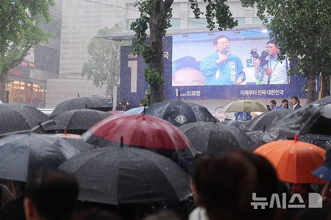 [순천=뉴시스] 권창회 기자 = 15일 전남 순천시 연향동 패션의거리에서 열린 이재명 더불어민주당 대선 후보의 유세에서 시민들이 폭우 속에도 이 후보의 연설을 듣고 있다. 2025.05.15. kch0523@newsis.com