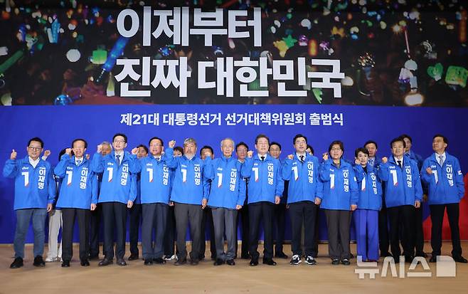 [서울=뉴시스] 조성우 기자 = 이재명(오른쪽 여섯 번째) 더불어민주당 대선후보와 박찬대, 윤여준 상임총괄선거대책위원장을 비롯한 총괄선거대책위원장들이 30일 오후 서울 여의도 국회 의원회관에서 열린 더불어민주당 제21대 대통령선거 '진짜 대한민국' 중앙선거대책위원회 출범식에서 선대위복을 입고 구호를 외치고 있다. 왼쪽부터 박지원, 이석연 공동선거대책위원장, 김경수, 김부겸, 김동명 총괄선거대책위원장, 윤여준 상임총괄선거대책위원장, 이재명 대선후보, 박찬대 상임총괄선거대책위원장, 정은경, 강금실 총괄선거대책위원장, 정동영 공동선거대책위원장. 2025.04.30. xconfind@newsis.com