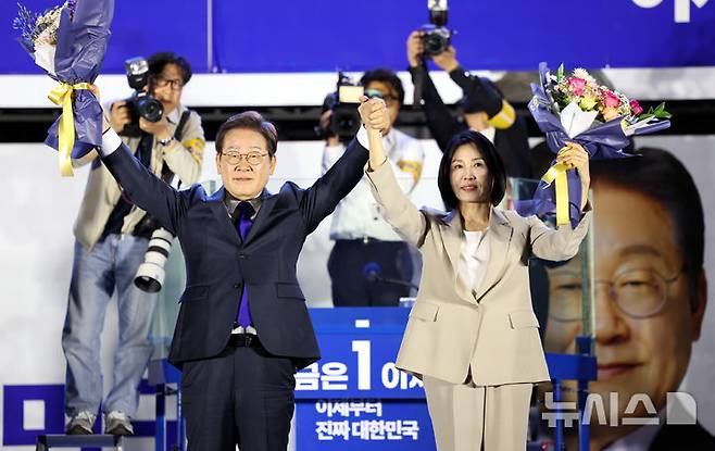 [서울=뉴시스] 조성우 기자 = 이재명 대통령과 김혜경 여사가 4일 오전 서울 여의도 국회 앞에서 열린 국민 개표방송 행사에서 꽃다발을 받은 뒤 시민들을 향해 인사하고 있다. 2025.06.04. xconfind@newsis.com