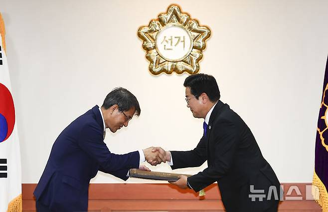 [과천=뉴시스] 김근수 기자 = 노태악(왼쪽) 중앙선거관리위원장이 4일 오전 경기 과천시 중앙선거관리위원회 회의실에서 열린 제21대 대통령 당선증 교부식에서 박찬대 더불어민주당 상임 총괄선거대책위원장에게 당선증을 전달하고 있다. 2025.06.04. ks@newsis.com