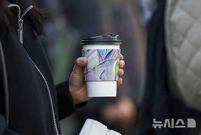 [서울=뉴시스] 정병혁 기자 = 서울 종로구 광화문네거리에서 한 시민이 커피를 들고 이동하고 있다. 2024.11.05. jhope@newsis.com