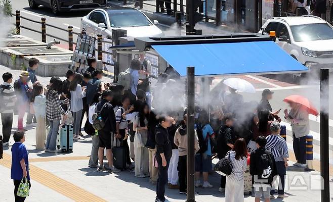 [부산=뉴시스]    レポーターHa Kyung -min =市民と観光客は、4日に釜山の釜山の釜山の横断歩道の前に設置された日陰の下に冷却霧で冷却しています。 2025.06.04。 yulnetphoto@newsis.com