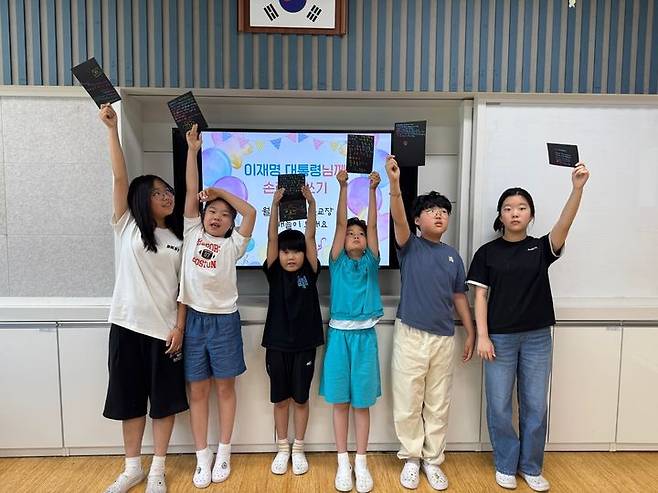 [안동=뉴시스] 김진호 기자 = 이재명 대통령 모교인 안동시 월곡초등학교 학생들이 4일 선배인 이재명 대통령에게 당선 축하 손 편지를 쓴 뒤 들어보이고 있다. (사진=월곡초 제공) 2025.06.04. photo@newsis.com *재판매 및 DB 금지