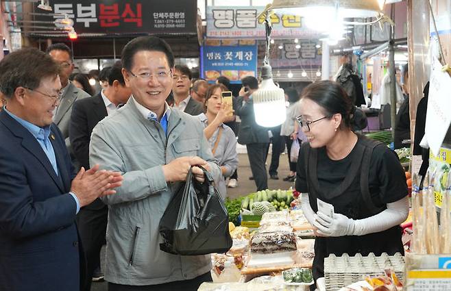 [목포=뉴시스] 송창헌 기자 = 김영록 전남지사가 4일 오전 목포 동부시장을 방문, 제21대 대통령 선거 투표에 참여해준 도민께 감사 인사를 하며 물건을 구입하고 있다. (사진=전남도 제공) 2025.06.04 photo@newsis.com  *재판매 및 DB 금지