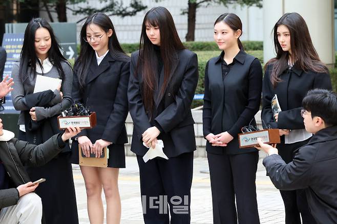그룹 뉴진스(왼쪽부터 하니, 민지, 혜인, 해린, 다니엘)가 지난 3월 7일 서울 서초구 서울중앙지방법원에서 어도어 측이 멤버들을 상대로 제기한 ‘기획사 지위보전 및 광고계약 체결 등 금지’ 가처분 첫 심문기일을 마친 후 취재진 질문에 답하고 있다. (사진=연합뉴스)