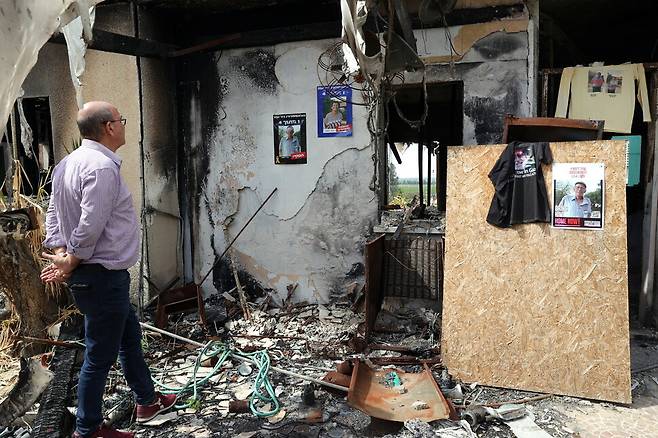 3월3일(현지시각) 이스라엘 남부 키부츠 니르 오즈에서 한 남성이 희생자 가족의 사진이 걸린 집 안을 바라보고 있다. 2023년 10월7일 하마스의 기습 공격으로 키부츠 주민 수십명이 인질로 잡혔고 살해됐다. 니르오즈/EPA 연합뉴스