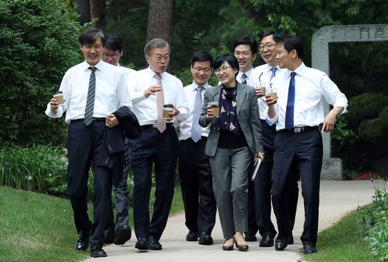 문재인 대통령이 2017년 5월 11일 청와대 참모진과 오찬을 함께한 뒤 커피를 들고 청와대 경내를 산책하고 있다.