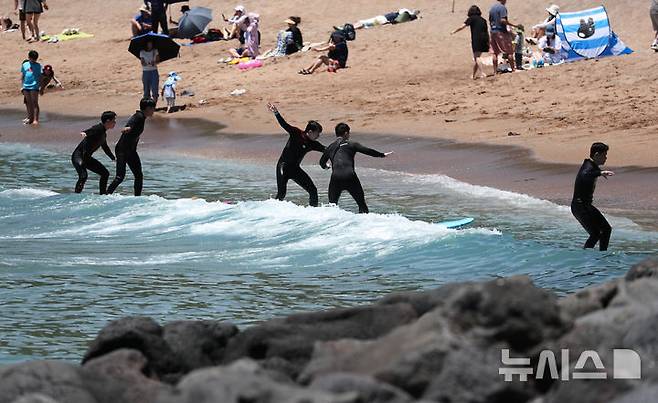 [서귀포=뉴시스] 우장호 기자 = 여름 날씨를 보인 5일 제주 서귀포시 중문색달해수욕장에서 물놀이객이 서핑을 배우며 즐거운 시간을 보내고 있다. 2025.06.05. woo1223@newsis.com
