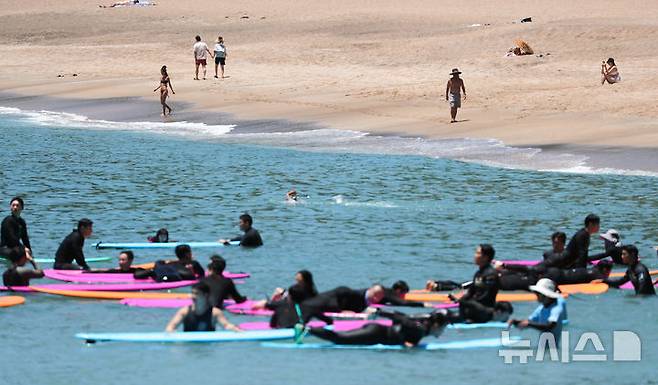 [서귀포=뉴시스] 우장호 기자 = 여름 날씨를 보인 5일 제주 서귀포시 중문색달해수욕장에서 물놀이객이 백사장 위를 걸어가고 있다. 2025.06.05. woo1223@newsis.com