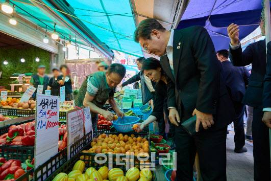 이재명 대통령과 김혜경 여사가 6일 사당동 남성사계시장을 깜짝방문해 식료품을 구매하고 있다. (대통령실 제공)
