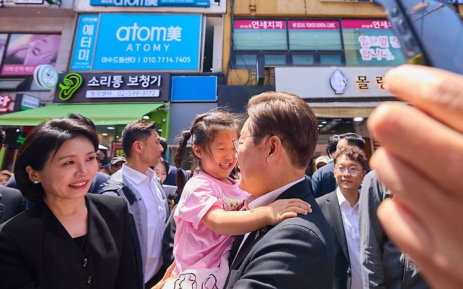 이재명 대통령과 김혜경 여사가 6일 서울 사당동 남성시장을 방문해 어린이를 안아주고 있다. /대통령실