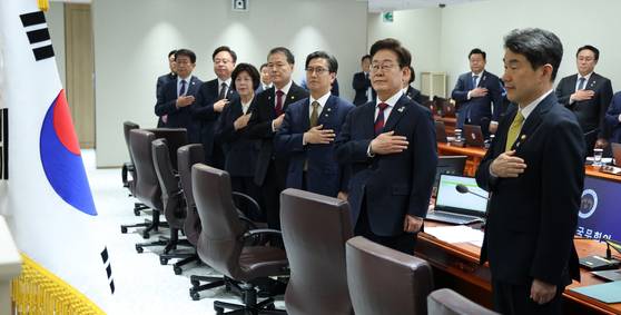 이재명 대통령이 5일 오전 서울 용산 대통령실에서 열린 국무회의에서 국민의례를 하고 있다. 이 대통령은 윤석열 정부가 임명한 국무위원들과 가진 회의에서 “우리는 국민에게 위임받은 업무를 하는 대리인들”이라며 “어색하지만 공직에 있는 기간만큼은 최선을 다해 달라”고 당부했다. [연합뉴스]