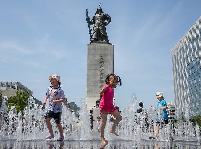 6일 오후 서울 종로구 광화문광장 분수대를 찾은 어린이들이 더위를 식히고 있다. 뉴스1