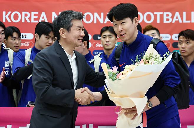축구대표팀 주장 손흥민이 정몽규 축구협회장으로부터 꽃다발을 전달받고 악수를 나누고 있다. [뉴스1]