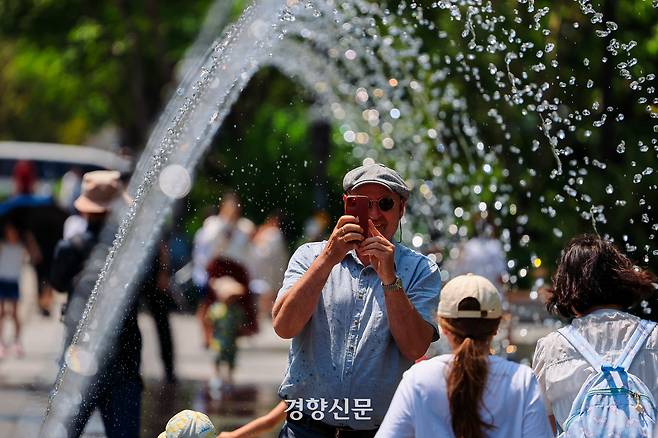 광화문 광장을 찾은 관광객들이 분수대를 지나고 있다。이준헌 기자