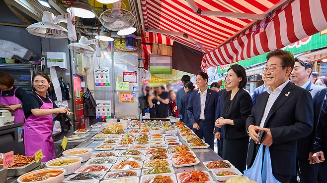 이재명 대통령과 부인 김혜경 여사가 6일 서울 사당동 남성사계시장을 방문해 상인과 대화를 나누고 있다. 대통령실 제공.