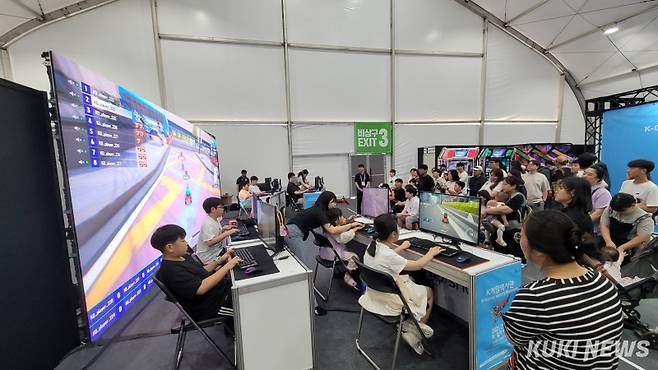 관람객들 인기가 높은 천안 K-컬처박람회 ‘영상·웹툰·게임전시관’ 스피드 게임장. 6일 엄마(오른쪽) 응원을 받으며 한 어린이(흰색옷)가 경기를 하고 있다.&nbsp; 사진=조한필 기자