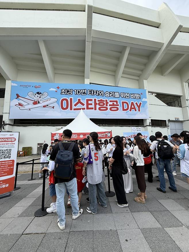 야구 팬들이 지난 5일 서울 송파구 잠실야구장 이스타항공 부스에 이벤트 참여를 위해 줄을 서 있다. 이스타항공 제공