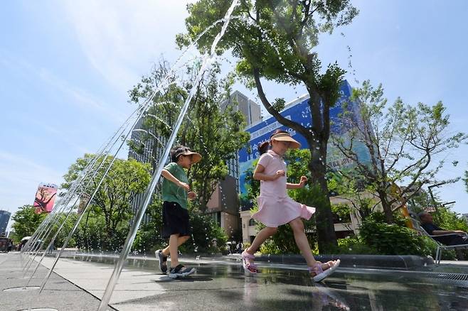 5일 서울 종로구 광화문광장에 설치된 분수터널에서 어린이들이 더위를 식히고 있다. [연합]