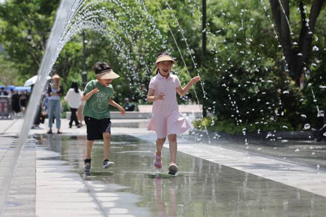 5일 서울 종로구 광화문광장에 설치된 분수터널에서 어린이들이 더위를 식히고 있다. 연합뉴스