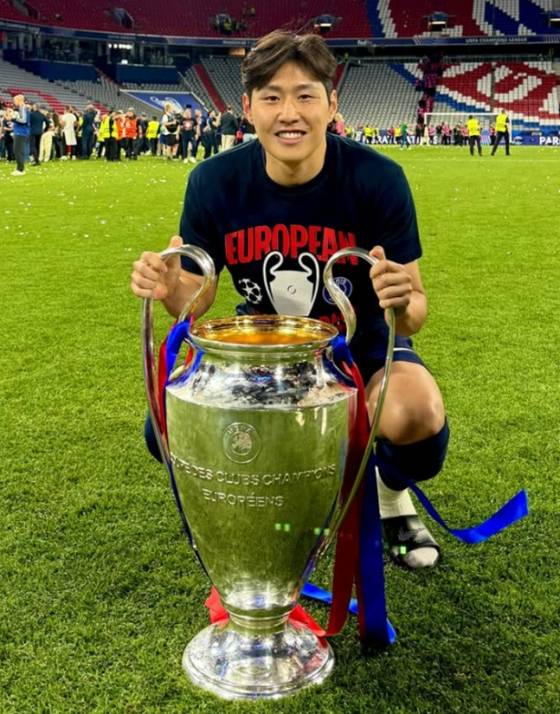 이강인이 지난 1일(한국시간) 독일 뮌헨의 알리안츠 아레나에서 2024~2025 유럽축구연맹(UEFA) 챔피언스리그 우승 후 트로피와 함께 기념 사진을 촬영하고 있다. /사진=이강인 SNS 갈무리