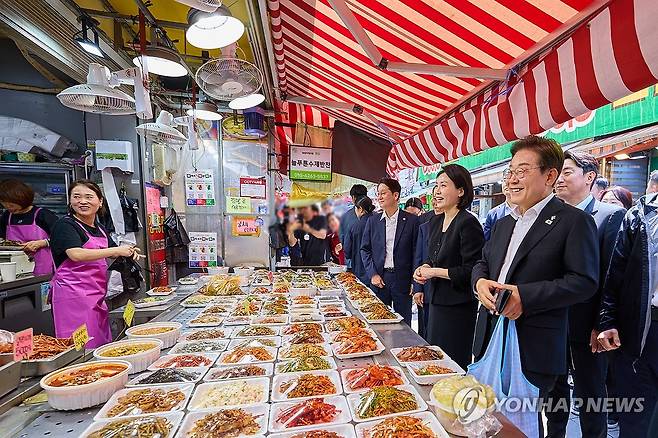 이재명 대통령 부부 전통시장 방문 (서울=연합뉴스) 이재명 대통령과 김혜경 여사가 6일 서울 동작구 남성시장을 방문해 상인과 인사하고 있다. 2025.6.6 [대통령실 제공. 재판매 및 DB 금지] photo@yna.co.kr